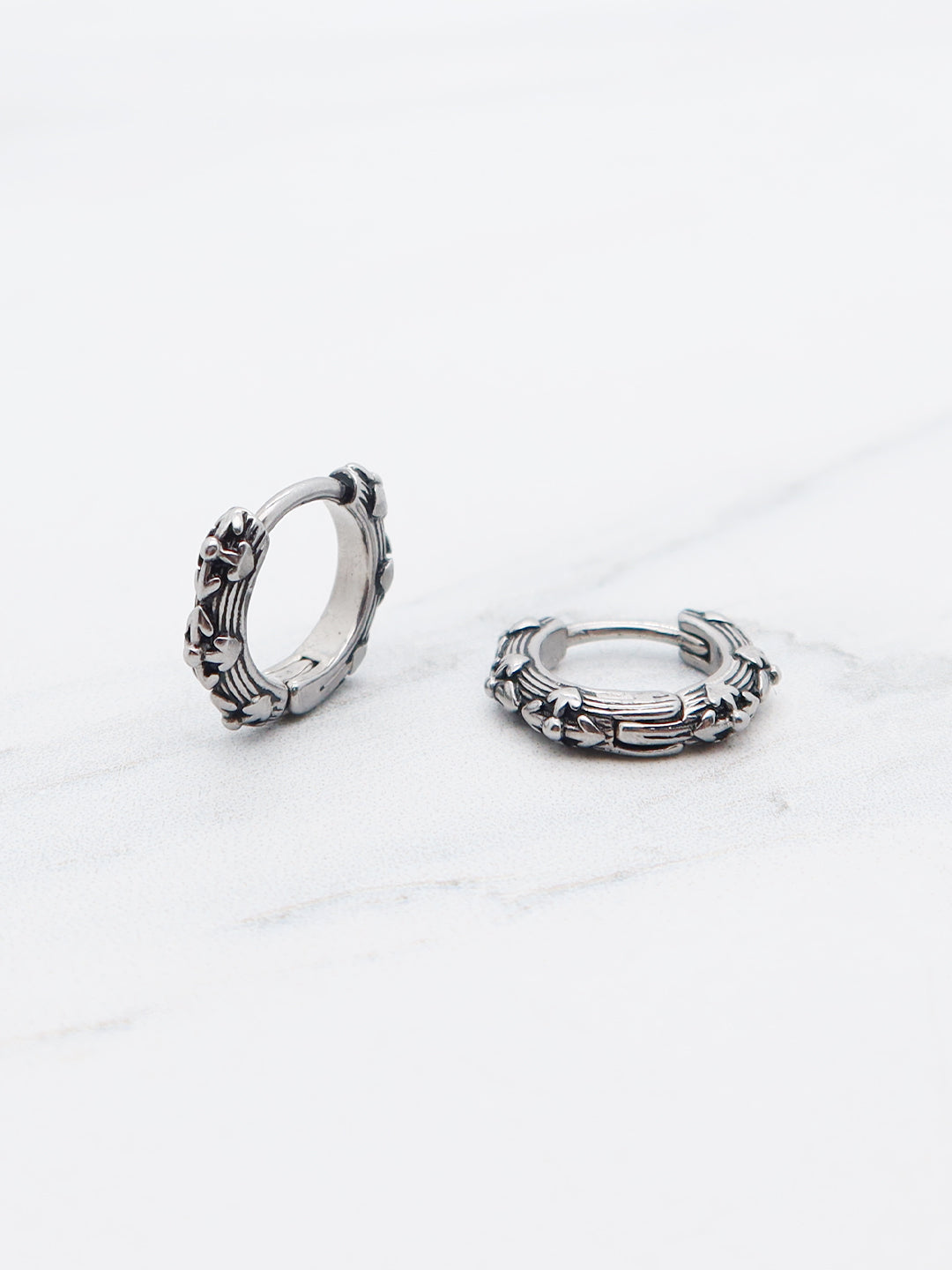 Floral wreath-inspired hoop earring with intricate vine and flower details, made of titanium.