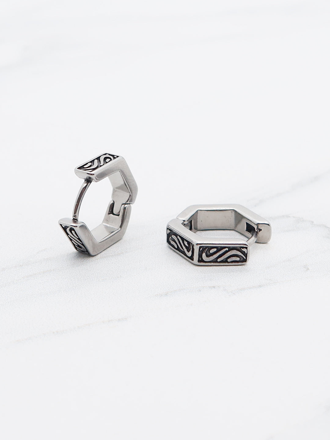 Hexagonal hoop earring in stainless steel with engraved patterns.