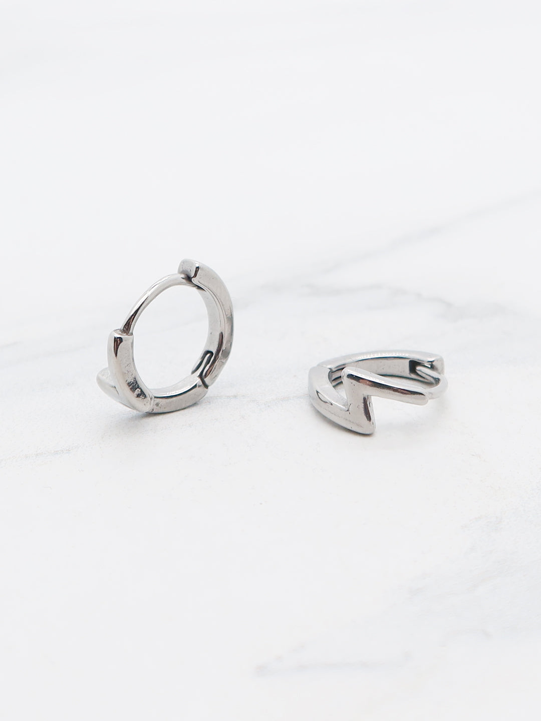 Titanium lightning bolt hoop earrings featuring a sharp cutout design, displayed on a white background.