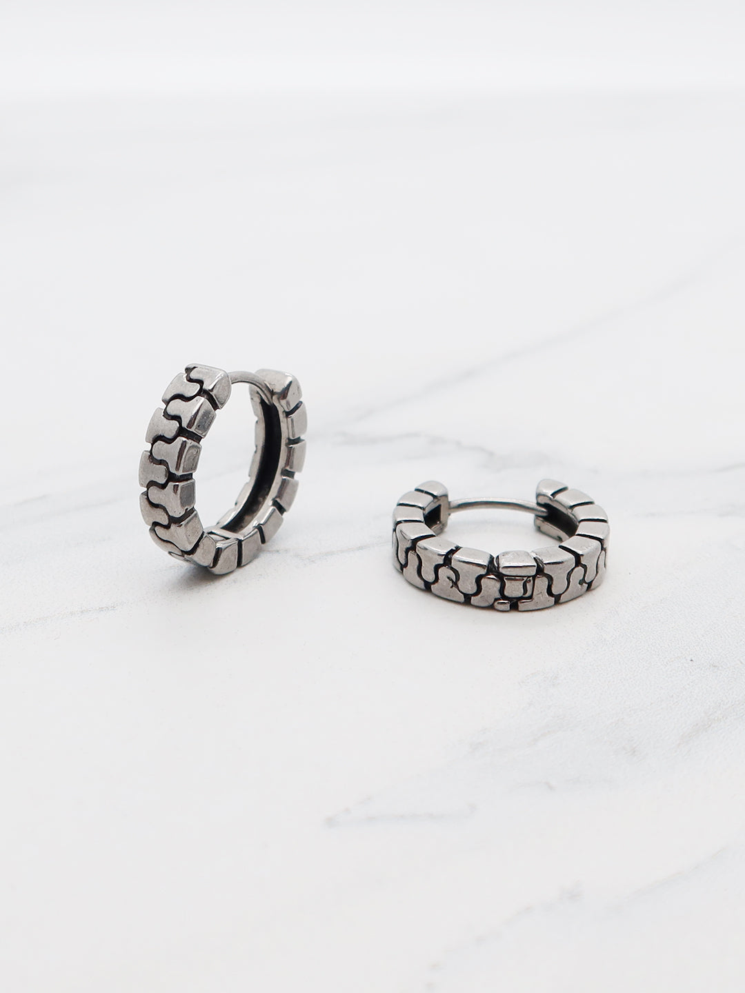 Mechanical link titanium hoop earrings with industrial-inspired design in huggie style, perfect for bold and modern fashion.