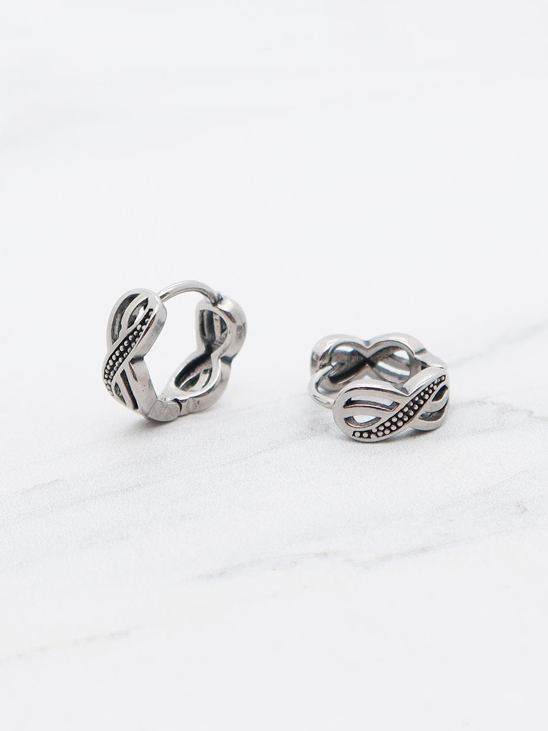Titanium hollow carved Middle Eastern-inspired hoop earrings with a hinged clasp closure.