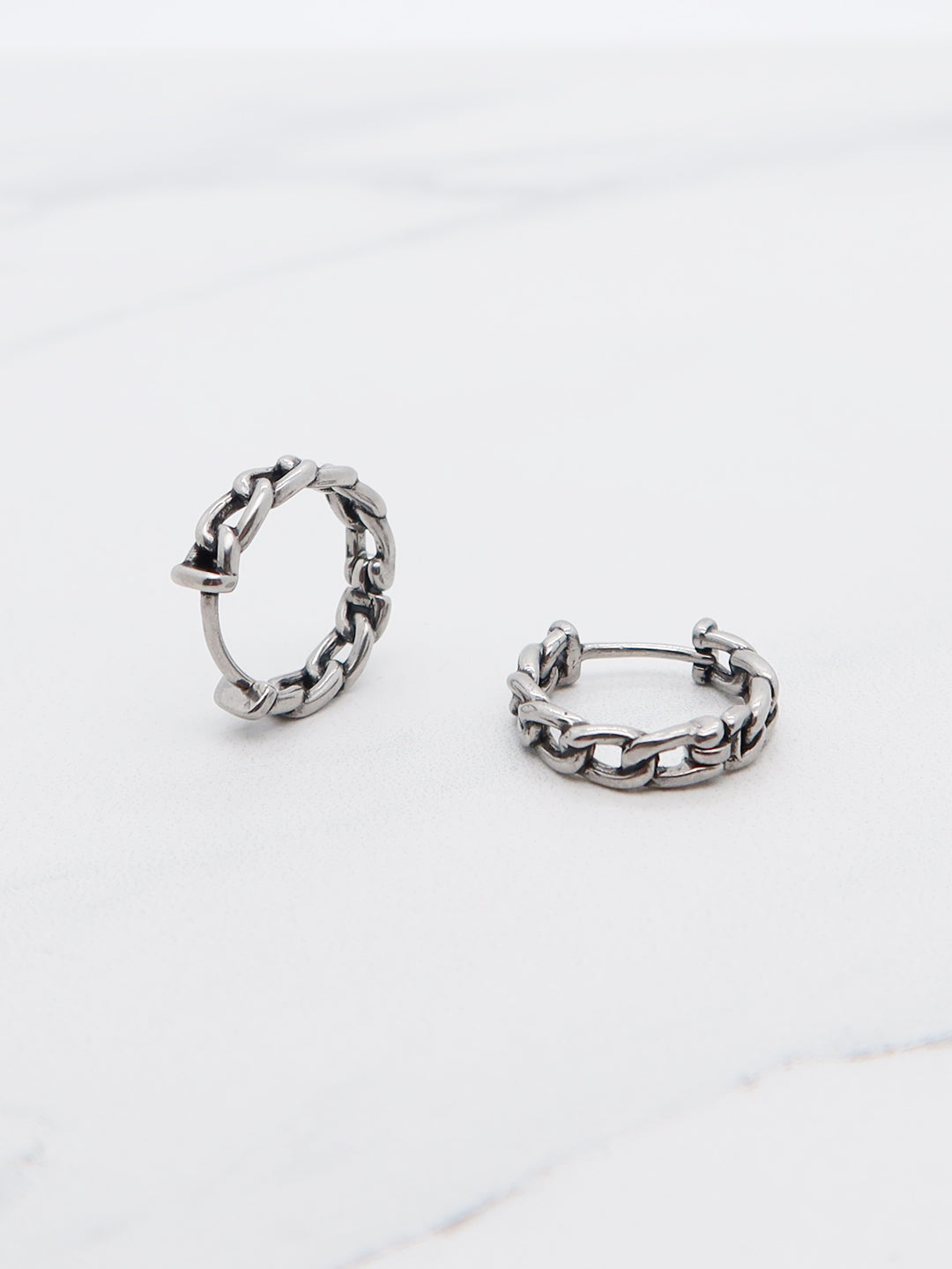Titanium chain-link hoop earrings in huggie-style design, perfect for bold and edgy fashion.