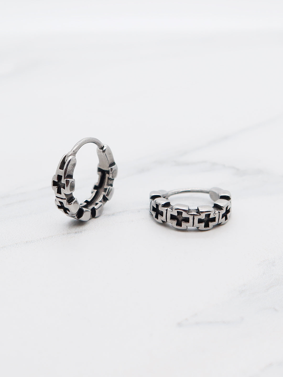 Close-up of titanium Cross Gothic Hoop Earrings with a chain link cross pattern.