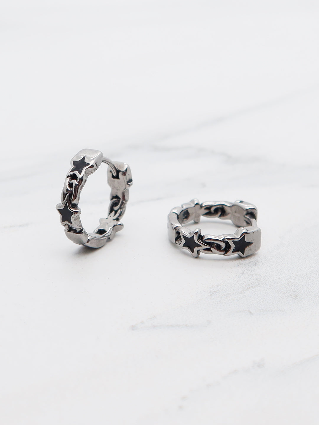 Close-up of Star Chain Hoop Earrings in titanium with a celestial-inspired star pattern.