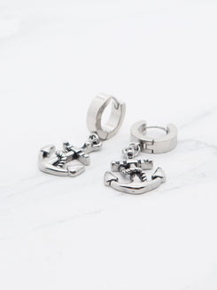 Titanium anchor dangle earrings on marble background