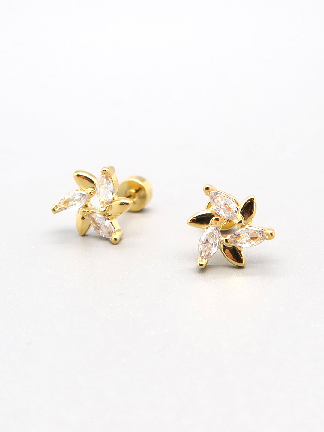 Gold flower-shaped titanium earrings with sparkling crystals – hypoallergenic, unisex, and perfect for sensitive skin.