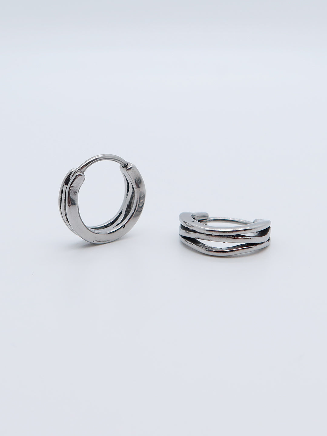 Wavy hoop earring in stainless steel with textured grooves.